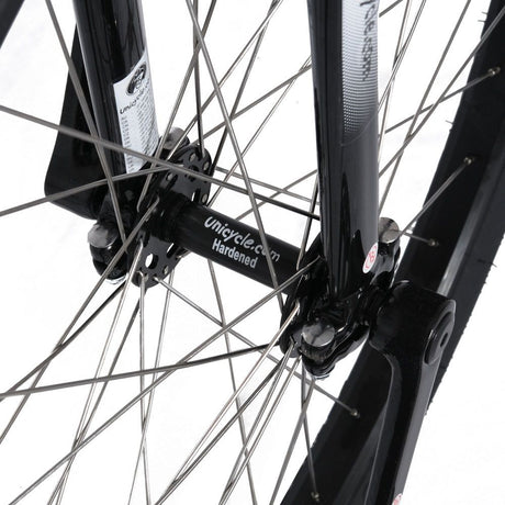 Närbild på svart nav märkt "Unicycle.com Hardened" och svart gaffel på en Penny Farthing 29". Visar silverekrar