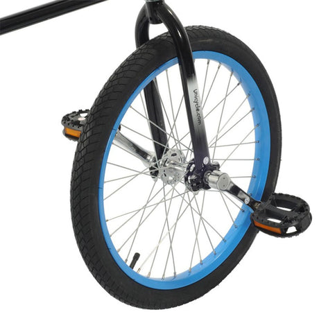 Detaljbild på det drivande bakhjulet på Hoppley Circus Bike med blå fälg, pedaler, och svart gaffel