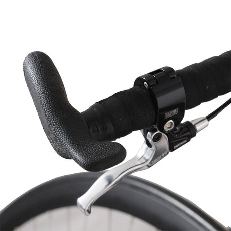 Närbild på höghjulingens styre med ergonomiskt svart grepp och Tektro-liknande silverfärgat bromshandtag