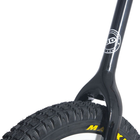 Närbild på den blanka svarta enhjulingsgaffeln som går tätt runt ett Maxxis-däck med grovt mönster.