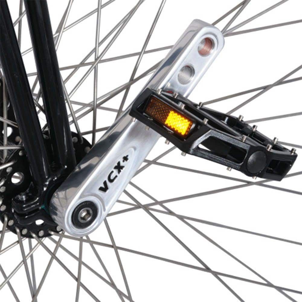 Närbild på den polerade Nimbus VCX Plus-vevarmen och svart pedal på höghjulingens framhjul, visar tydligt VCX+-märkningen