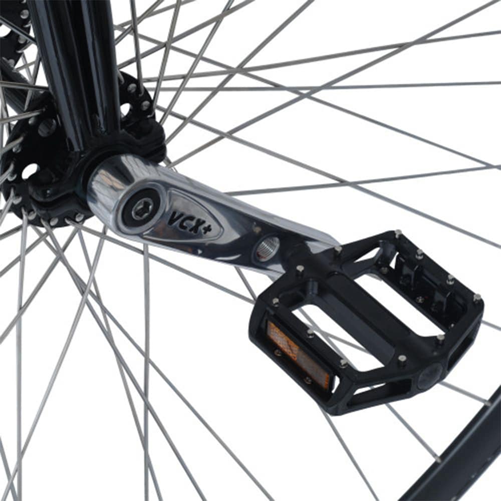 Närbild på höghjulingens nav och vevarm. Visar Nimbus VCX Plus-vevarmar i polerat stål och svarta aluminiumpedaler med dubbar